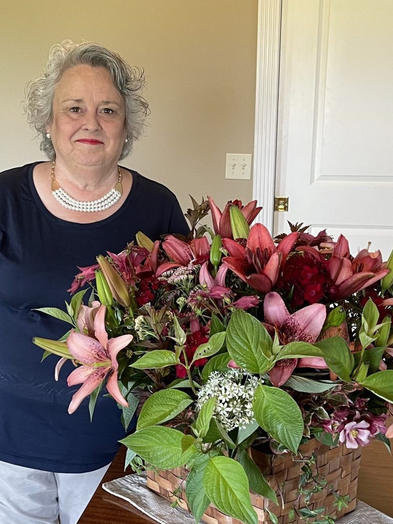 MaryAnne Nestor and a big basket of lilies.